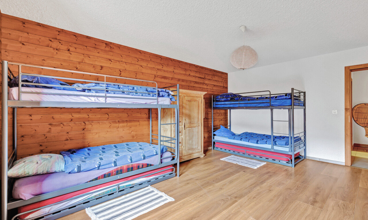 room featuring wood finished floors, wooden walls, and a textured ceiling