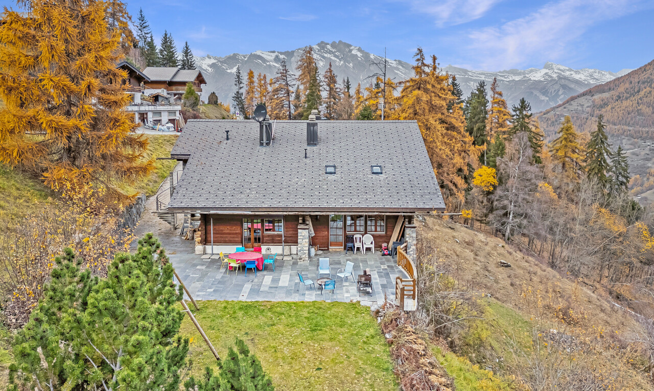 outdoor house with a mountain view, a patio area, and a lawn