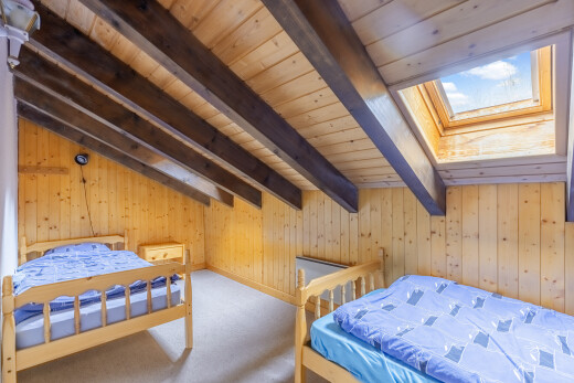 zimmer / schlafzimmer mit inside property, zusätzliches zimmer, holzwand, wood wall, und balkendecke
