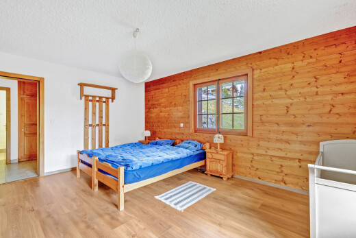 zimmer / schlafzimmer mit holzwand, wood wall, inside property, spritzputz decke, und textured ceiling