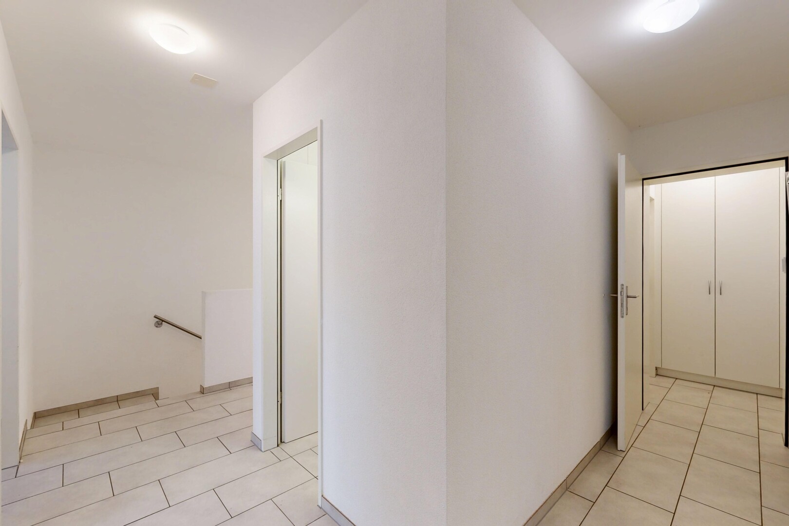 couloir avec light floor, palier à l'étage, sol en carrelage, tile floor, et inside property
