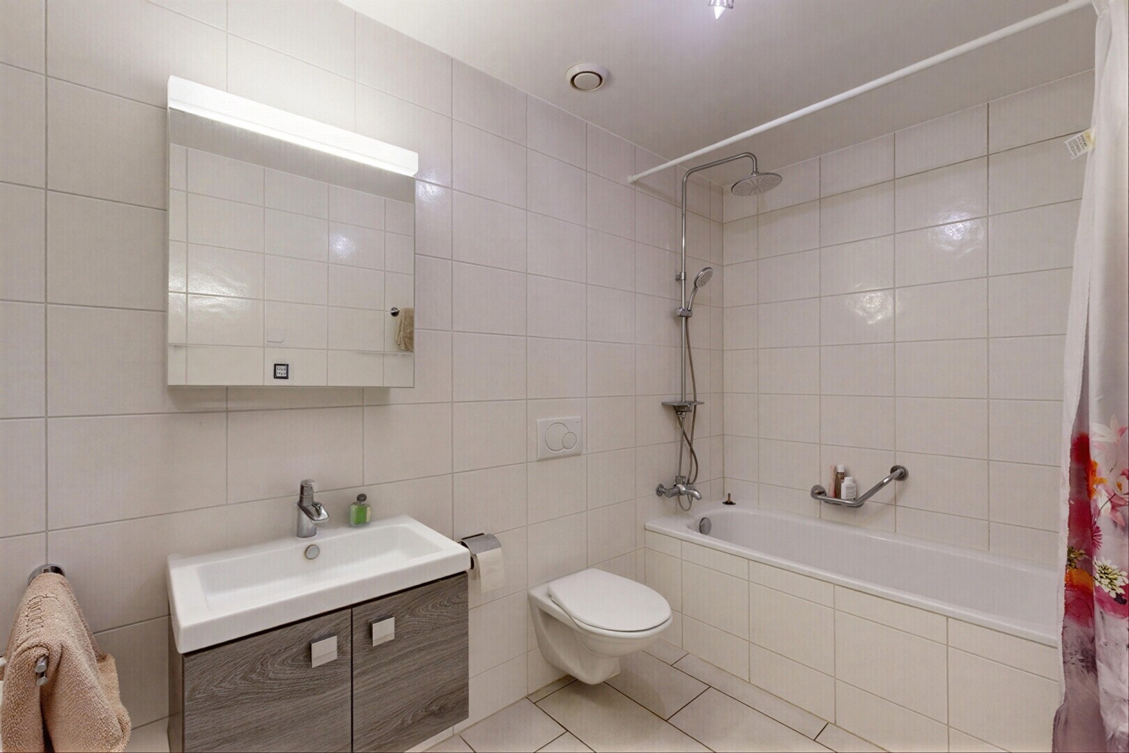 salle de bains avec salle de bain complète, mur en carrelage, tile wall, lavabo (ou coiffeuse selon le contexte), et miroir