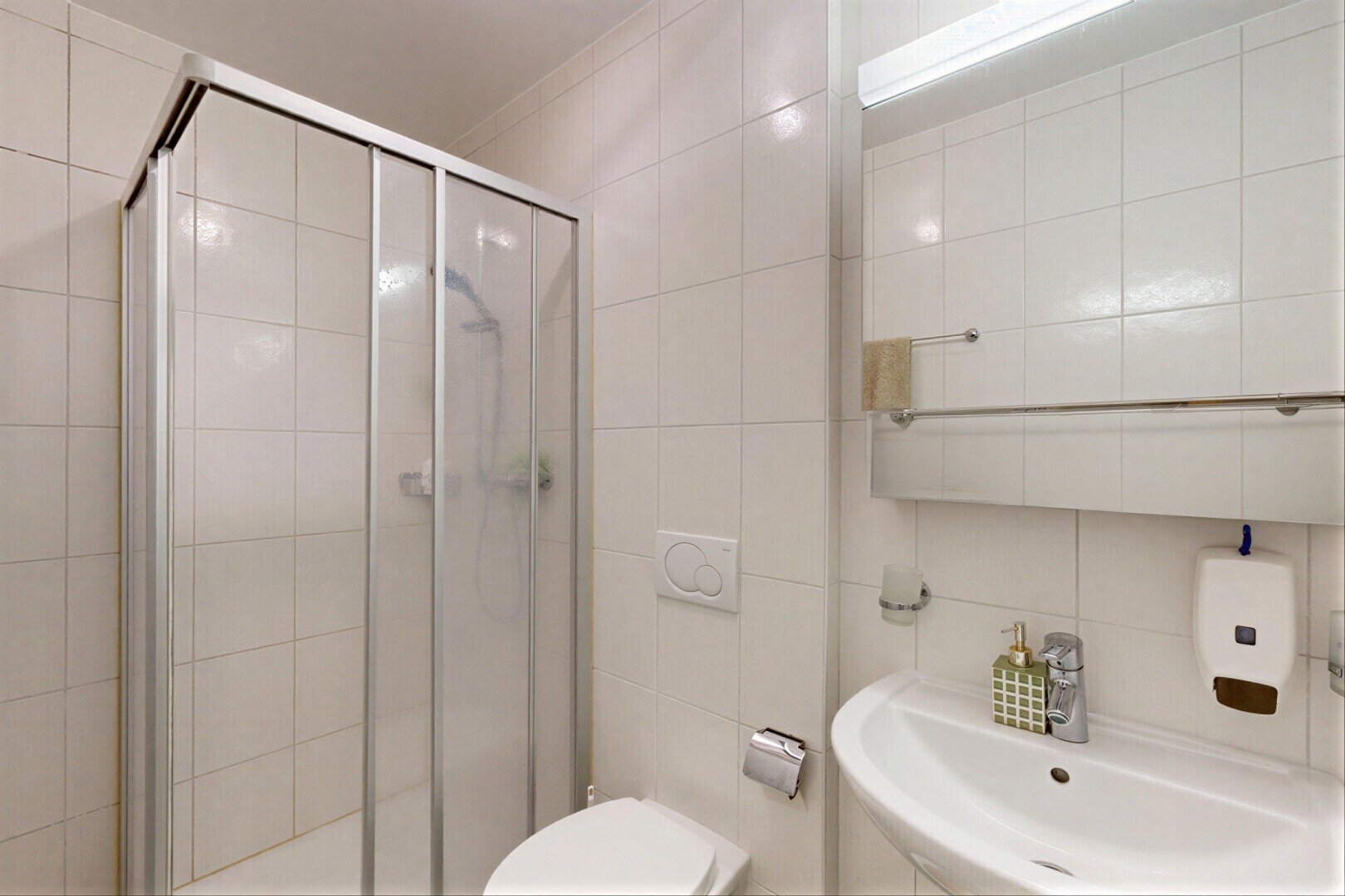 salle de bains avec salle de bain complète, miroir, évier, douche, et tile wall