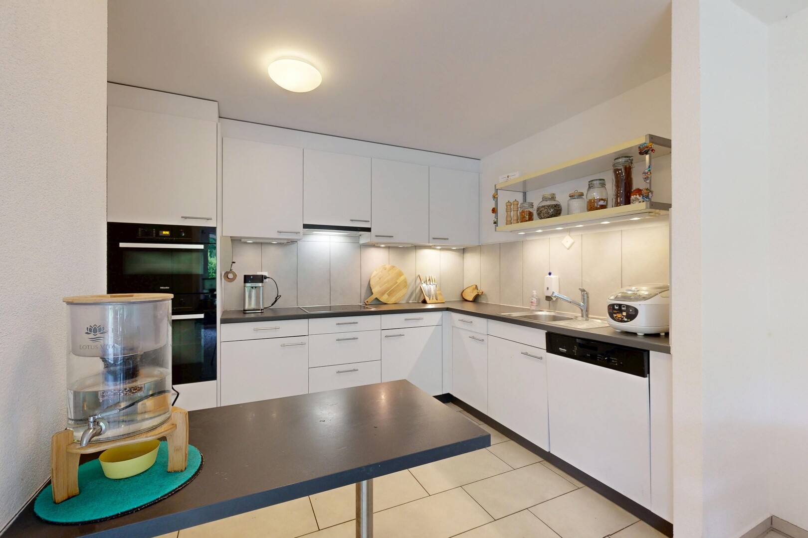 cuisine avec dark countertops, plans de travail, light floor, inside property, et white cabinets