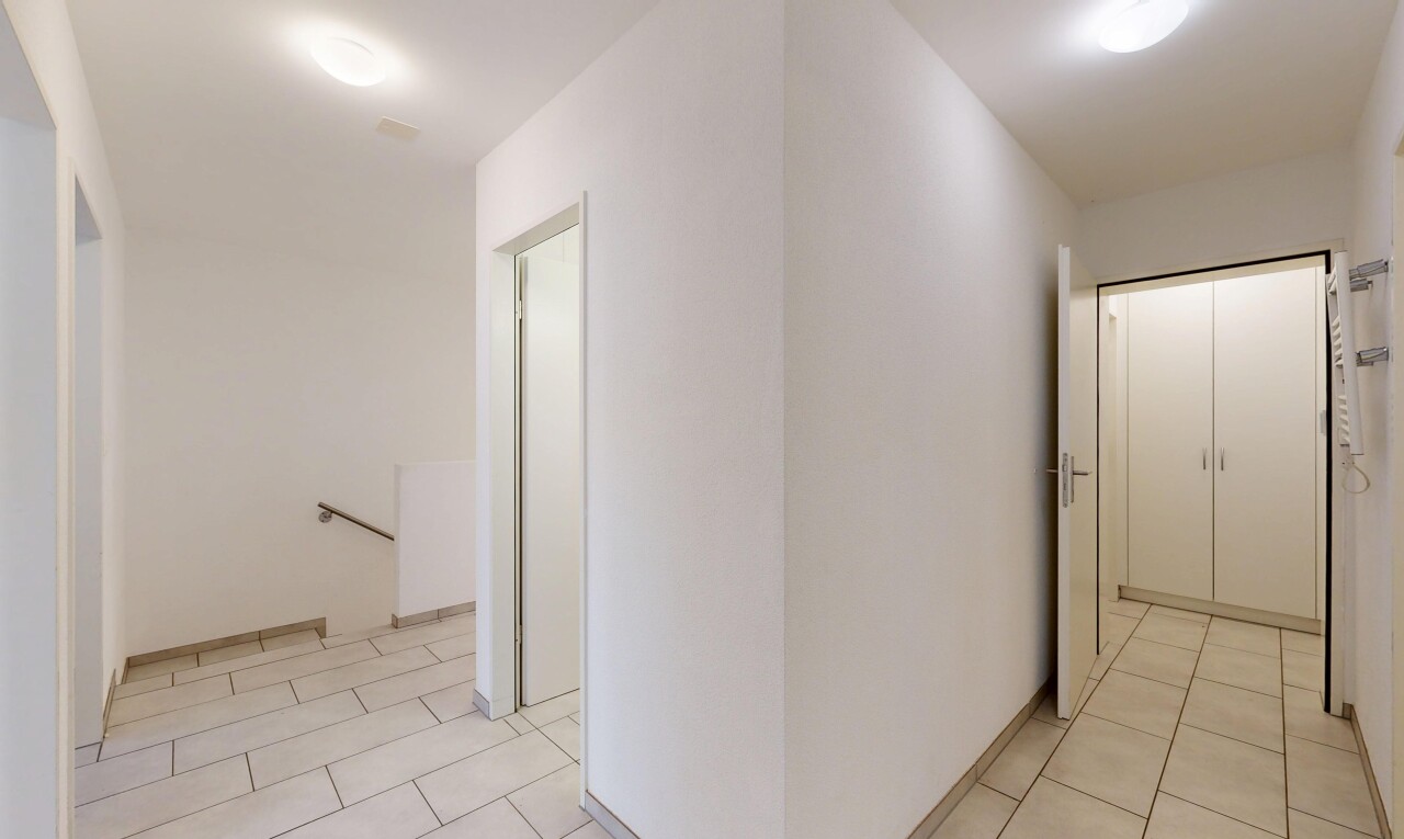 couloir avec light floor, palier à l'étage, sol en carrelage, tile floor, et inside property