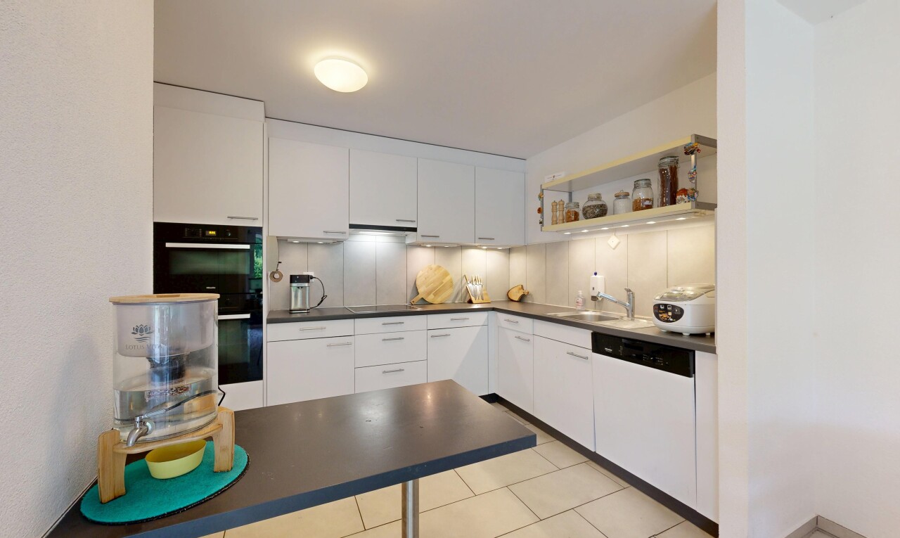 cuisine avec dark countertops, plans de travail, light floor, inside property, et white cabinets