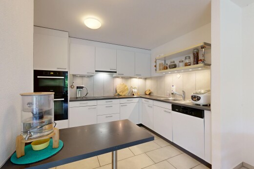 cuisine avec dark countertops, plans de travail, light floor, inside property, et white cabinets