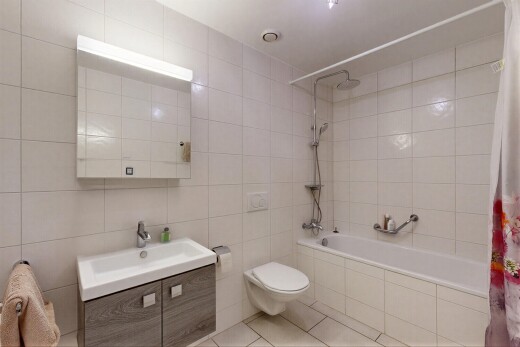 salle de bains avec salle de bain complète, mur en carrelage, tile wall, lavabo (ou coiffeuse selon le contexte), et miroir