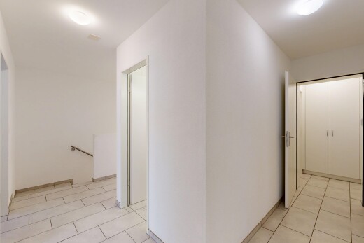 couloir avec light floor, palier à l'étage, sol en carrelage, tile floor, et inside property