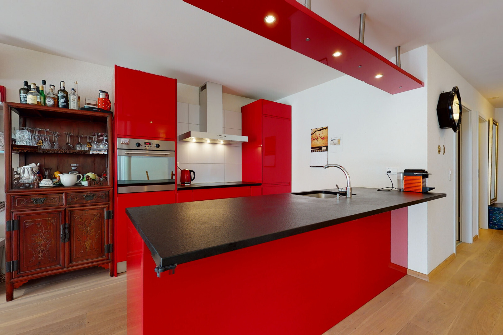 kitchen with oven, red cabinets, light wood-type flooring, and a peninsula