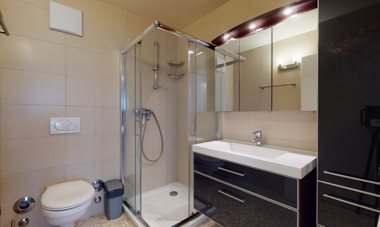 full bath with vanity, a shower stall, and tile walls