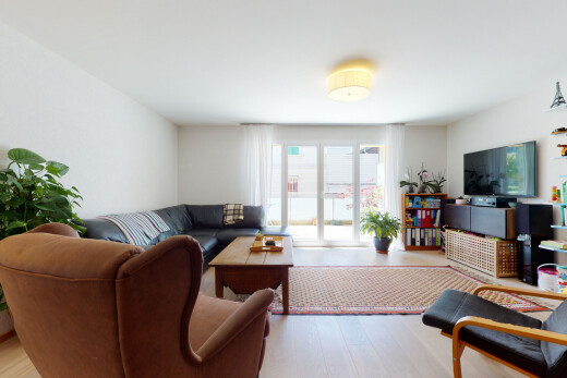 salon avec télévision, wood finish floor, sol en finition bois, drywall, et cloison sèche