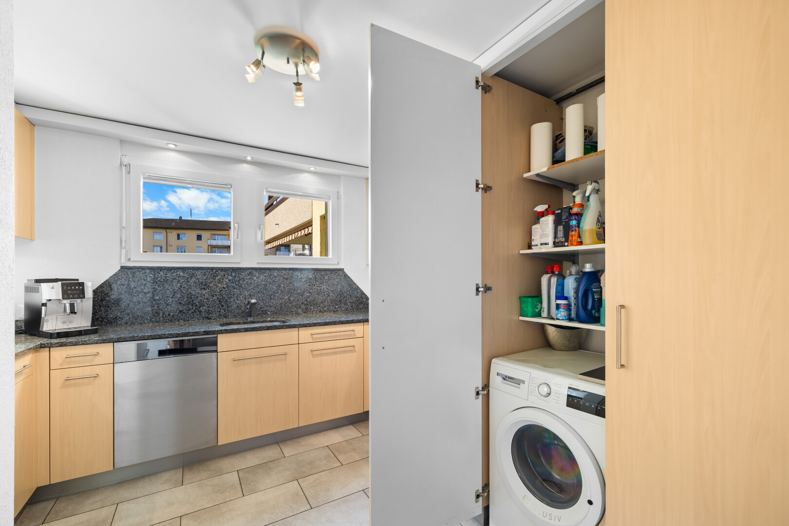 küche mit tumbler, hellbraune schränke, light brown cabinets, geschirrspülmaschine, und dark countertops