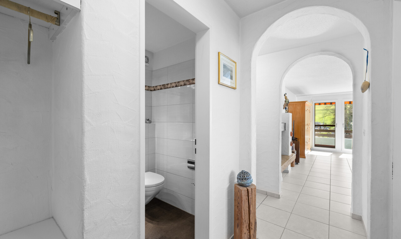 halle / korridor mit inside property, gewölbte gehwege, natürliches licht, natural light, und fliesenboden