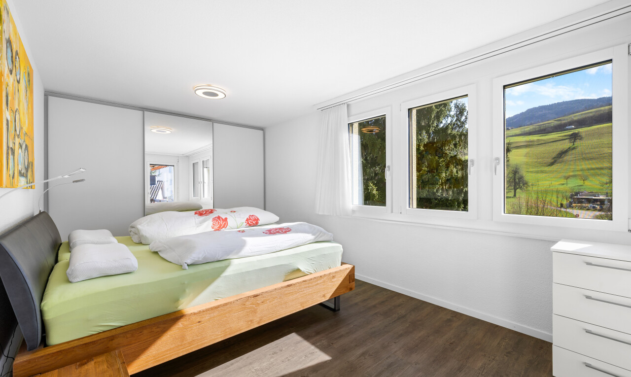 zimmer / schlafzimmer mit drywall, gipskartonwand, natural light, natürliches licht, und wood finish floor