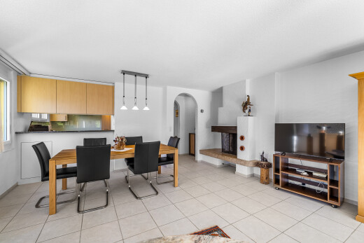 wohn- / esszimmer mit gewölbte gehwege, light floor, fernseher, inside property, und gipskartonwand