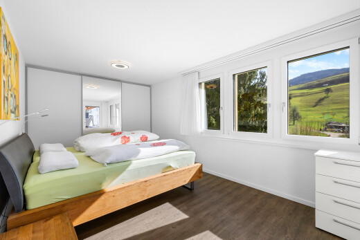 zimmer / schlafzimmer mit drywall, gipskartonwand, natural light, natürliches licht, und wood finish floor