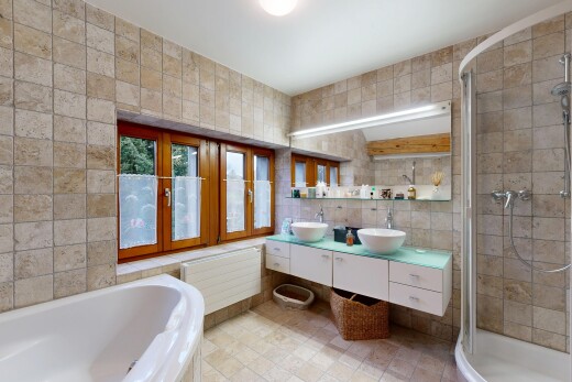 bathroom with radiator heating unit, double vanity, a shower stall, tile walls, and a garden tub