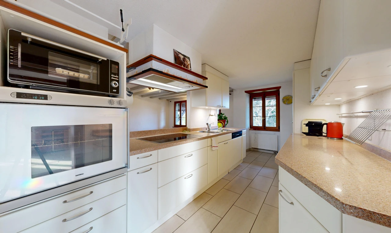 cuisine avec light floor, micro-ondes, four, light countertops, et armoires blanches