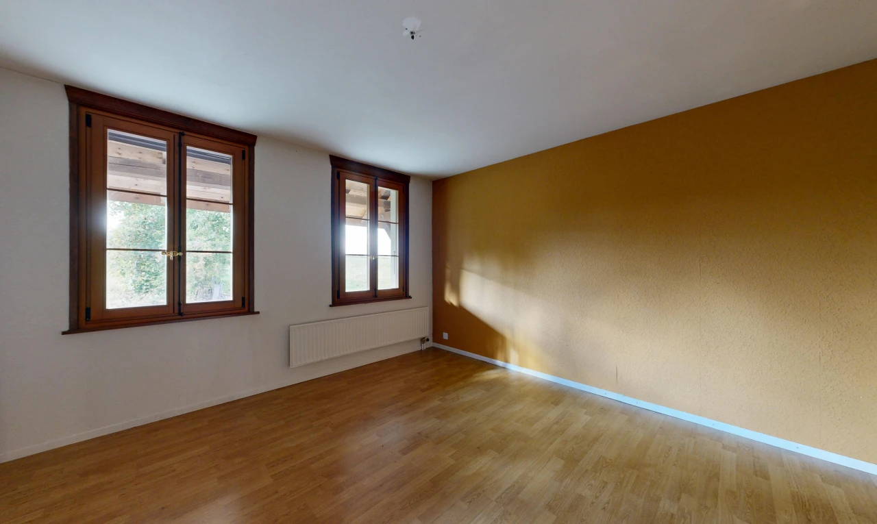 pièce vide avec lumière naturelle, radiateur, sol en finition bois, wood finish floor, et plinthes murales