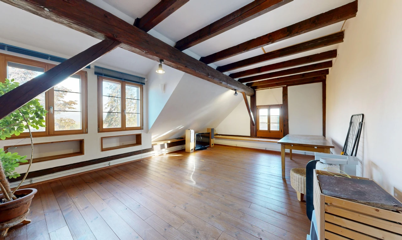 pièce vide avec pièce supplémentaire, plafond à poutres, beamed ceiling, lumière naturelle, et hardwood floor