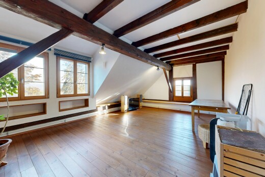 pièce vide avec pièce supplémentaire, plafond à poutres, beamed ceiling, lumière naturelle, et hardwood floor