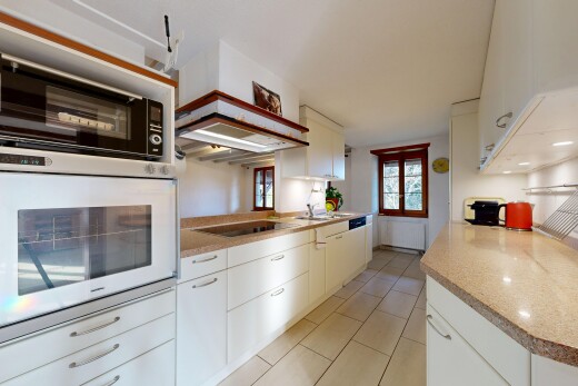 cuisine avec light floor, micro-ondes, four, light countertops, et armoires blanches