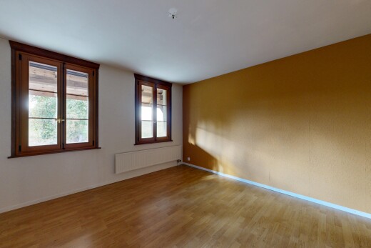 pièce vide avec lumière naturelle, radiateur, sol en finition bois, wood finish floor, et plinthes murales