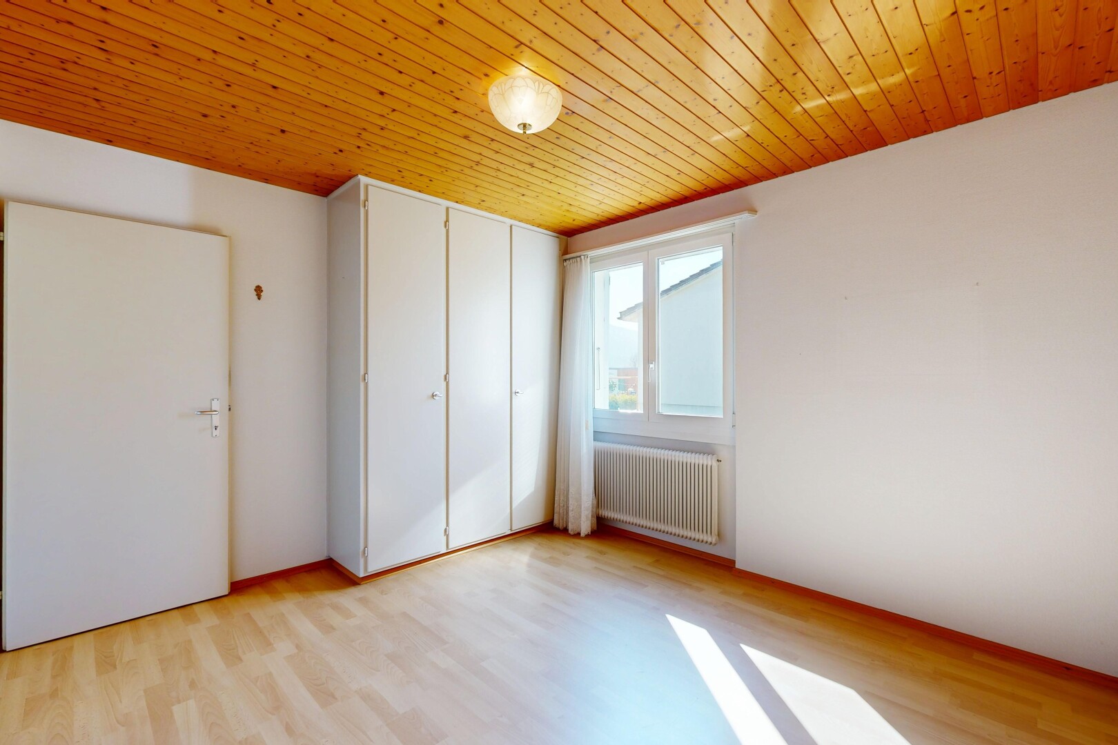 pièce vide avec lumière naturelle, natural light, radiateur, sol en finition bois, et wood finish floor