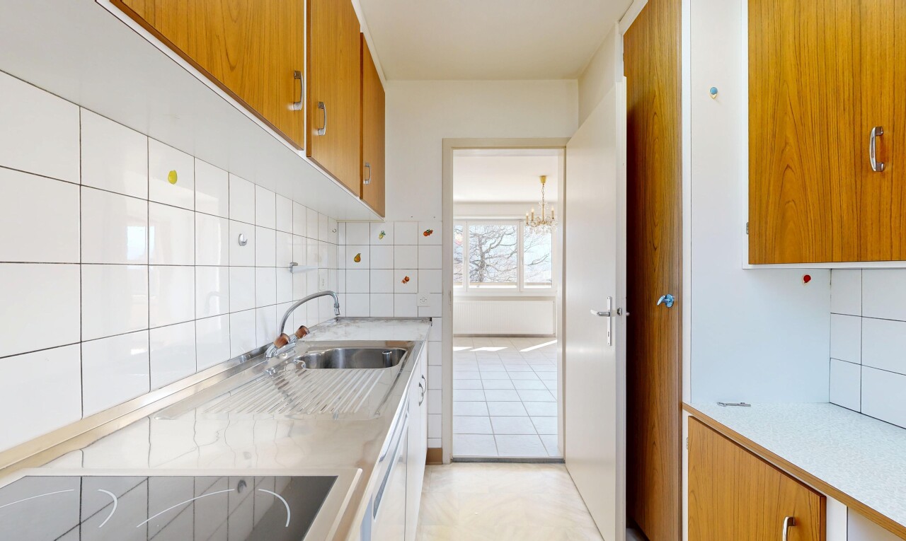 cuisine avec armoires marron moyen, medium brown cabinets, plans de travail, light countertops, et light floor