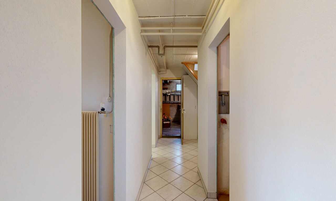 couloir avec cloison sèche, drywall, radiateur, inside property, et sol en carrelage