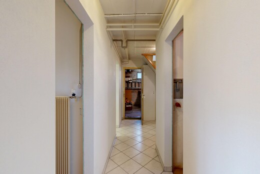 couloir avec cloison sèche, drywall, radiateur, inside property, et sol en carrelage