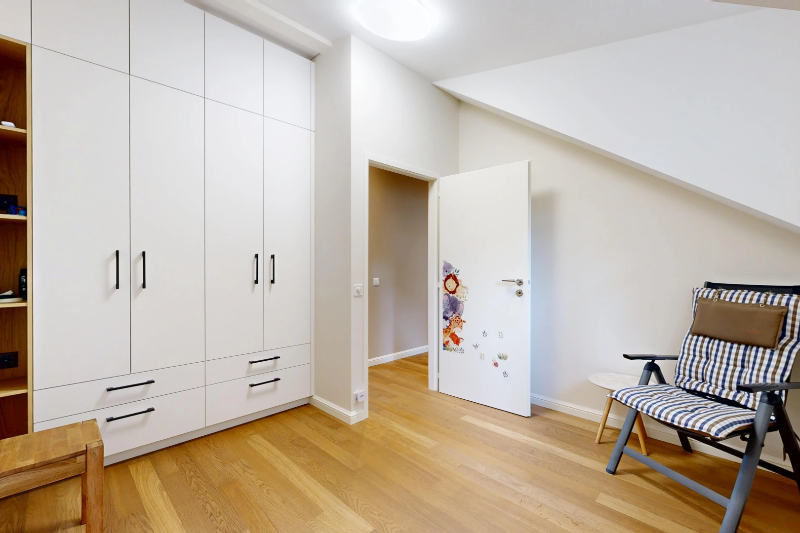chambre avec light floor, cloison sèche, drywall, sol en finition bois, et wood finish floor