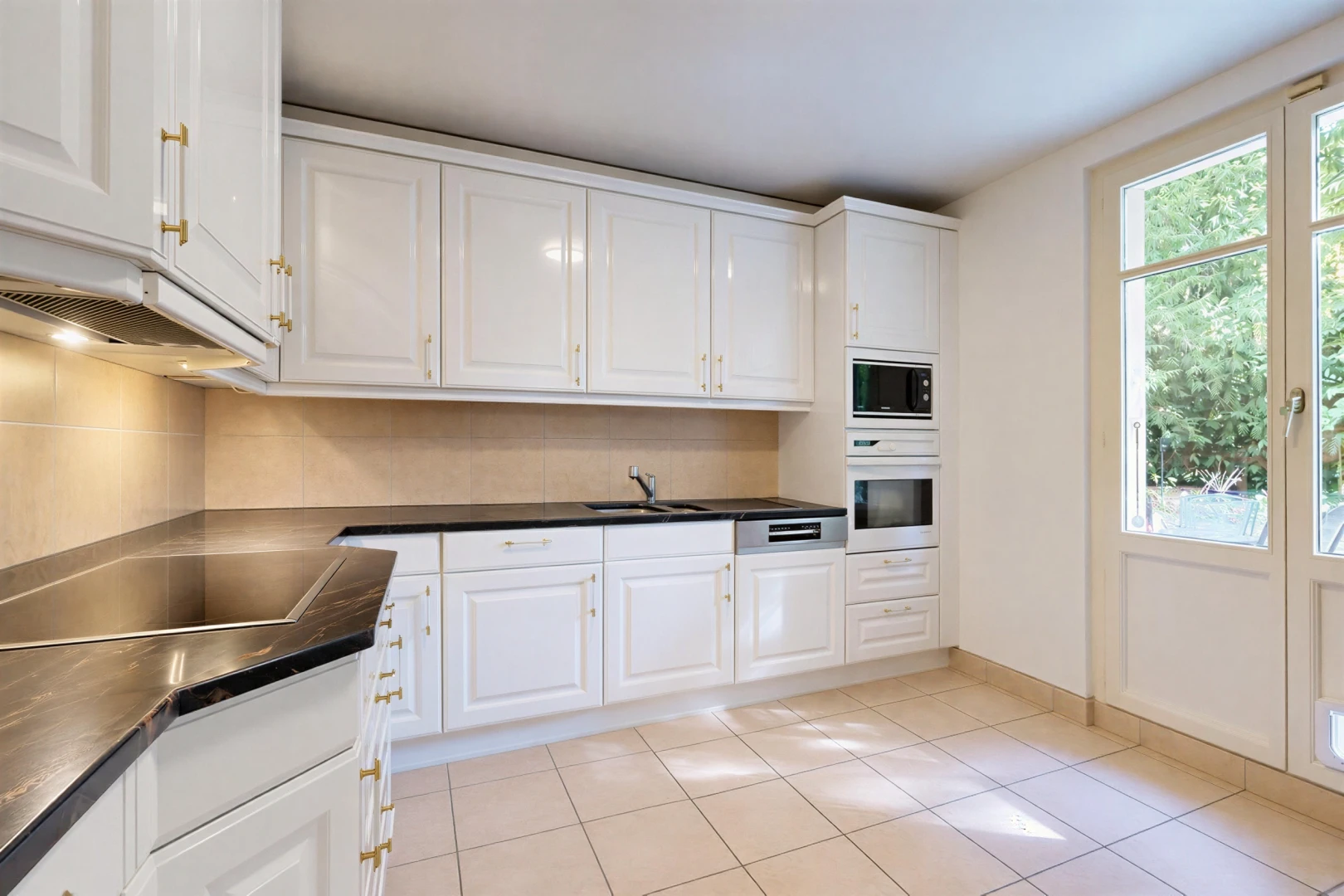 cuisine avec plans de travail, dark countertops, armoires blanches, white cabinets, et four
