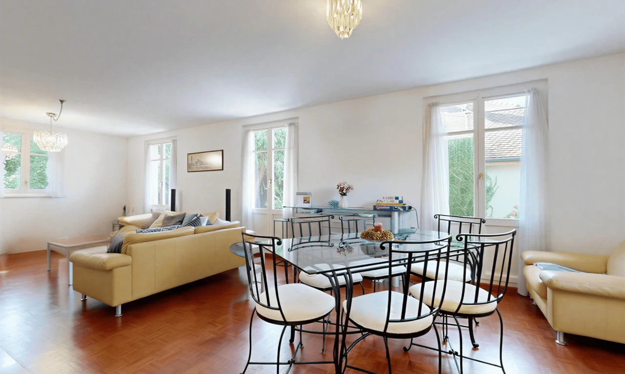 salon / salle à manger avec lumière naturelle, cloison sèche, drywall, sol en finition bois, et wood finish floor