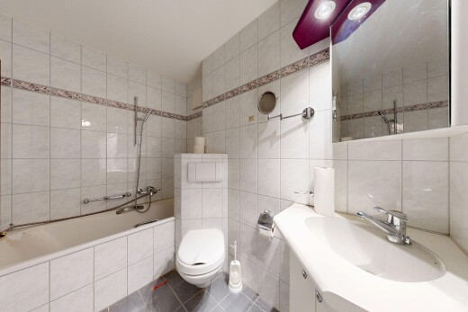 bathroom with tile walls, vanity, tile patterned floors, and tiled shower / bath combo