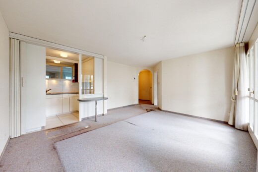 spare room featuring arched walkways and light colored carpet