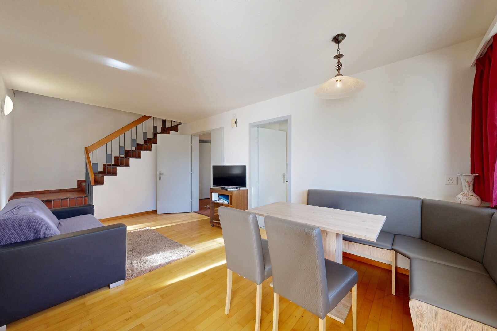 wohn- / esszimmer mit holzfußboden, wood finish floor, gipskartonwand, drywall, und fernseher