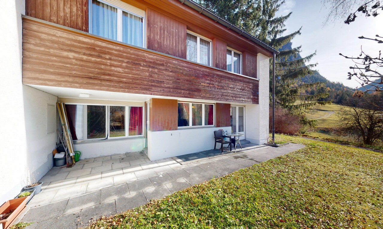 außenansicht mit terrasse, holzverkleidung, property visible, rasen, und vertikale verkleidung