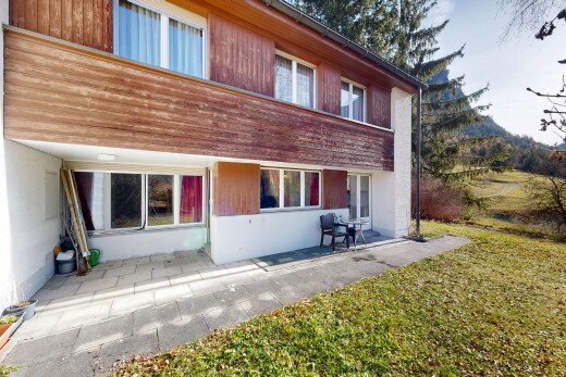 außenansicht mit terrasse, holzverkleidung, property visible, rasen, und vertikale verkleidung