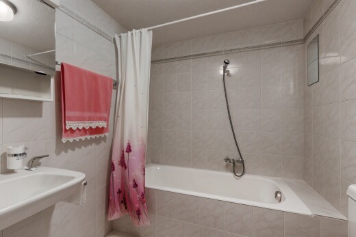 salle de bains avec tile wall, mur en carrelage, inside property, douche-bain combinés, et miroir