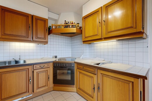 cuisine avec armoires marron moyen, dosseret, backsplash, hotte, et plans de travail en carrelage