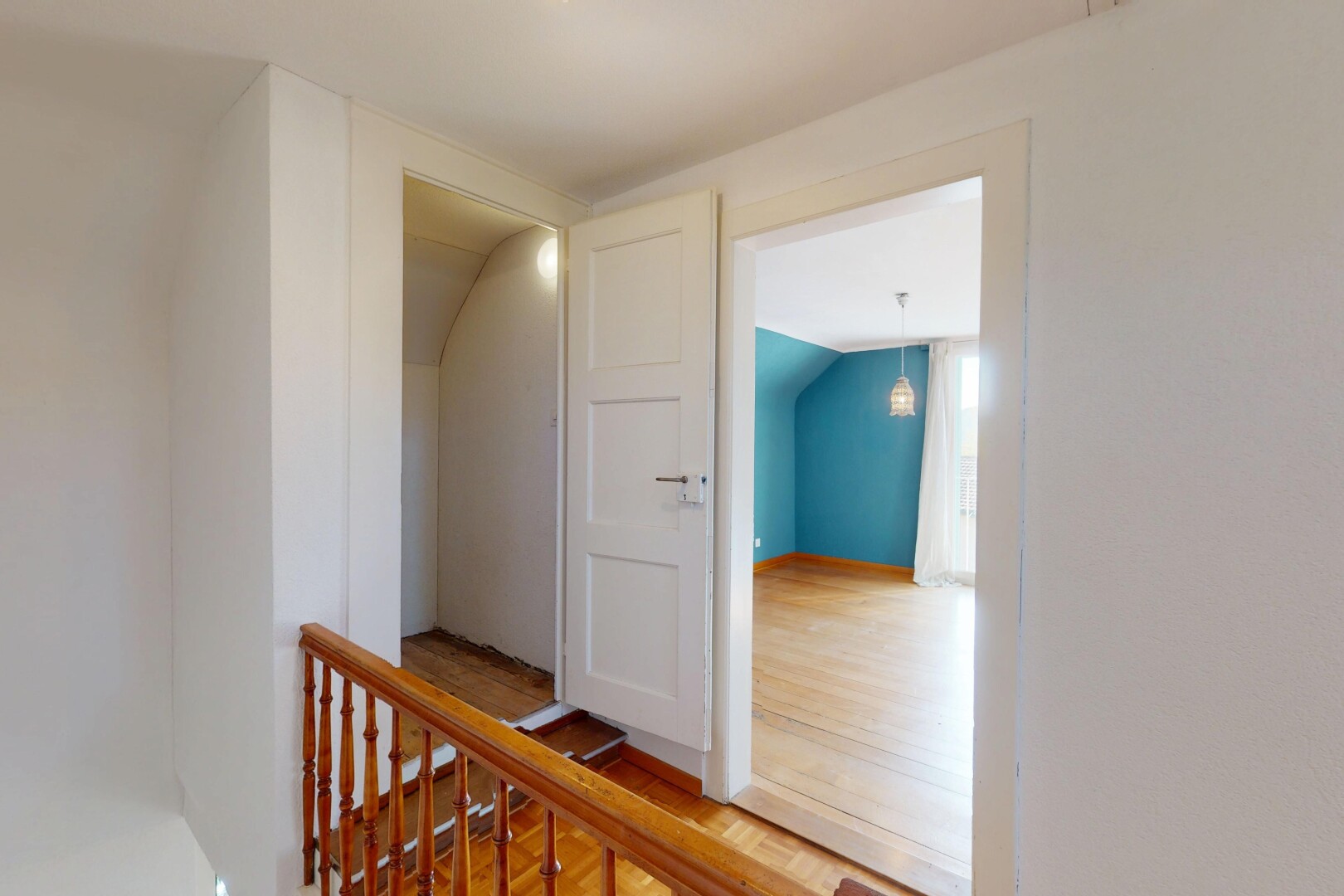 couloir avec plafond voûté, cloison sèche, palier à l'étage, et sol en finition bois