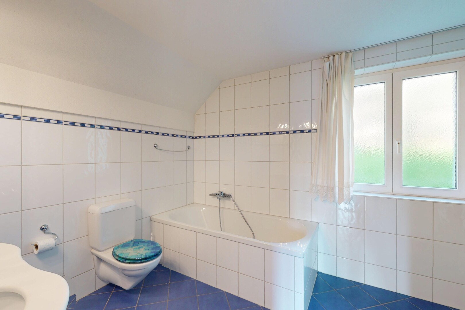 salle de bains avec mur en carrelage, toilette, bain, et sol en carrelage