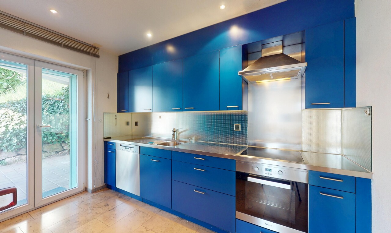 cuisine avec four, hotte, lave-vaisselle, et armoires bleues