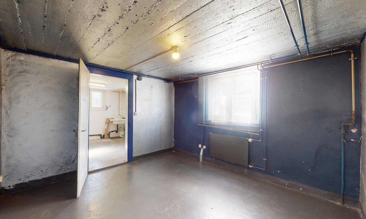 pièce vide avec sol en béton, sous-sol, cloison sèche, lumière naturelle, et plafond bas
