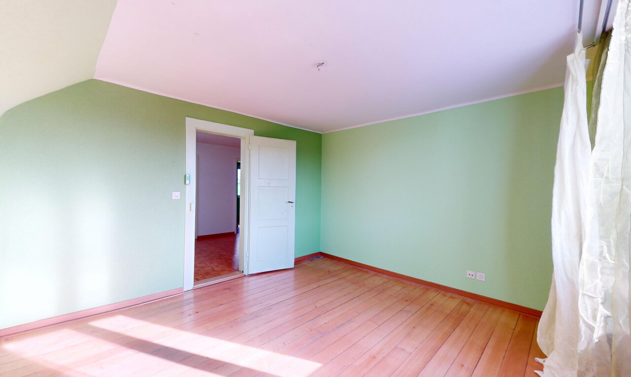 pièce vide avec plafond voûté, cloison sèche, plinthes murales, et sol en finition bois