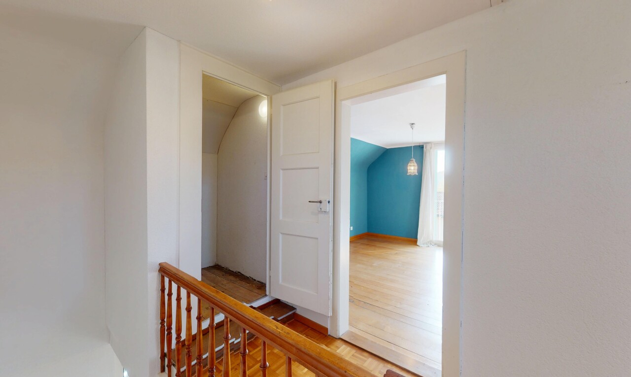 couloir avec plafond voûté, cloison sèche, palier à l'étage, et sol en finition bois