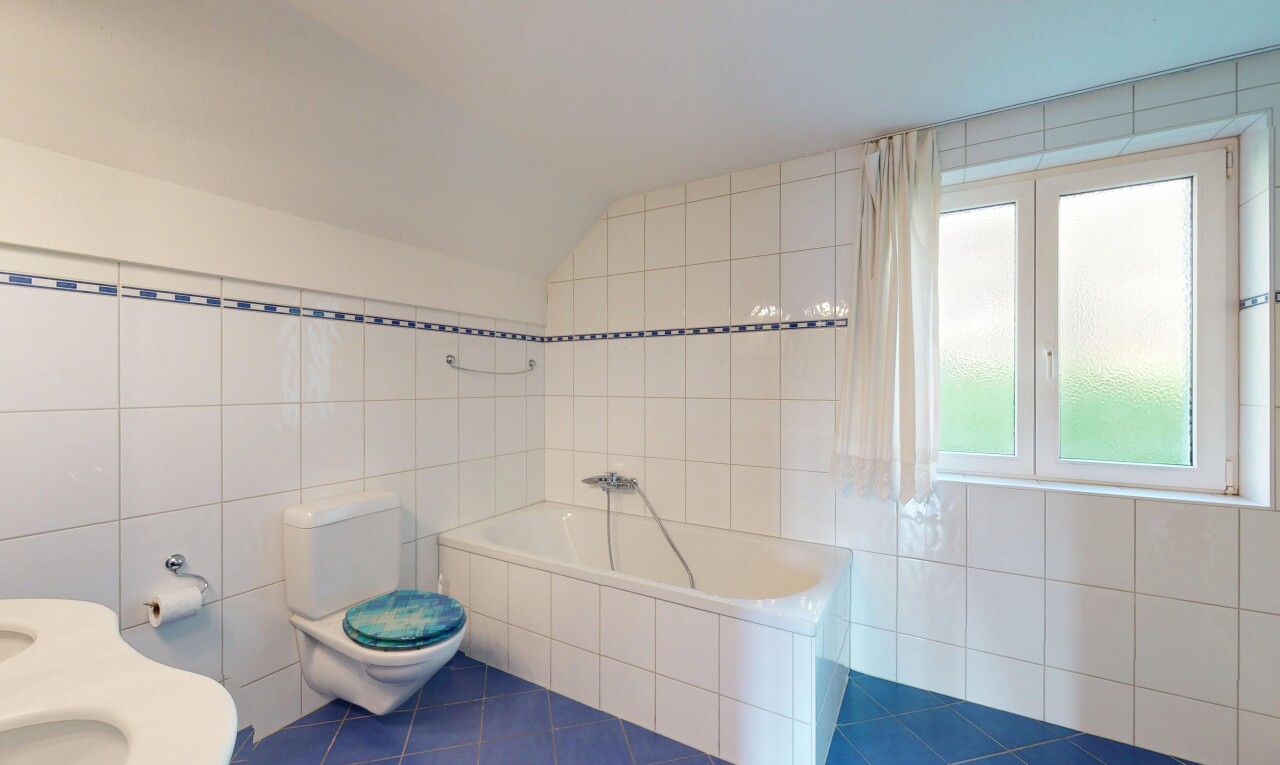 salle de bains avec mur en carrelage, toilette, bain, et sol en carrelage