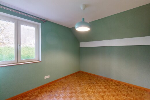 leerer raum mit dachschräge, gipskartonwand, natürliches licht, und sockelleisten